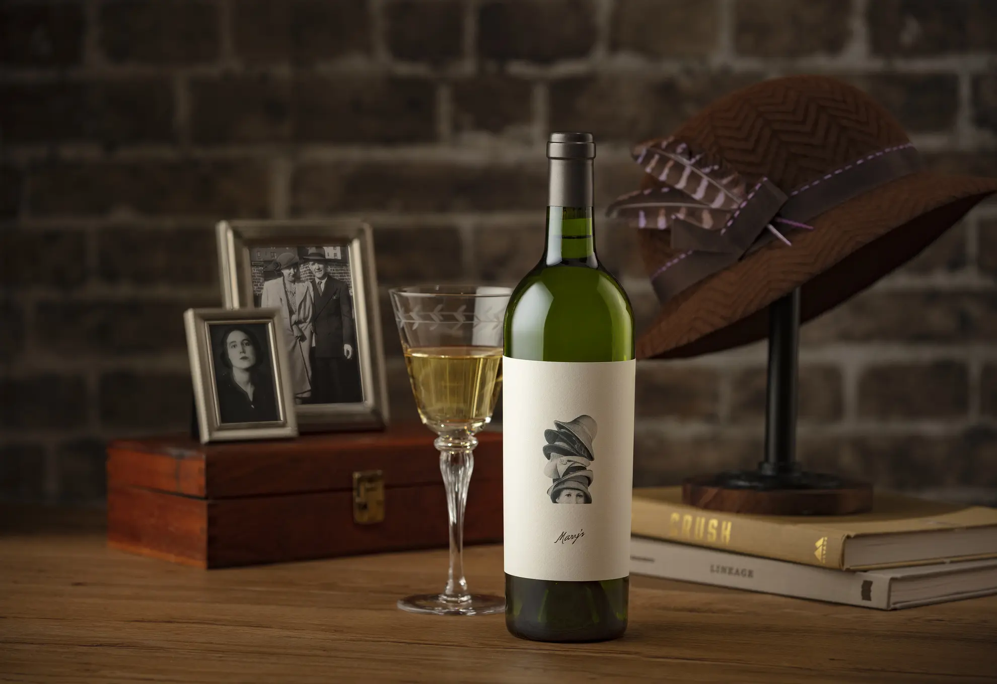 A bottle of wine and a hat on a table.