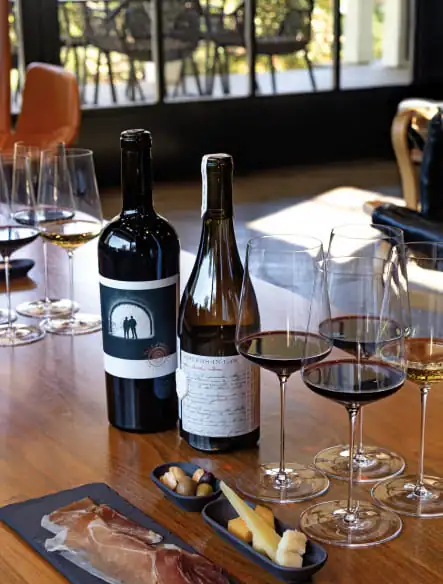 A table with wine glasses and a bottle of wine.