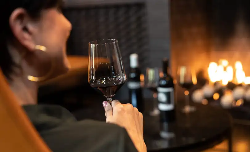 A woman holding a glass of wine.