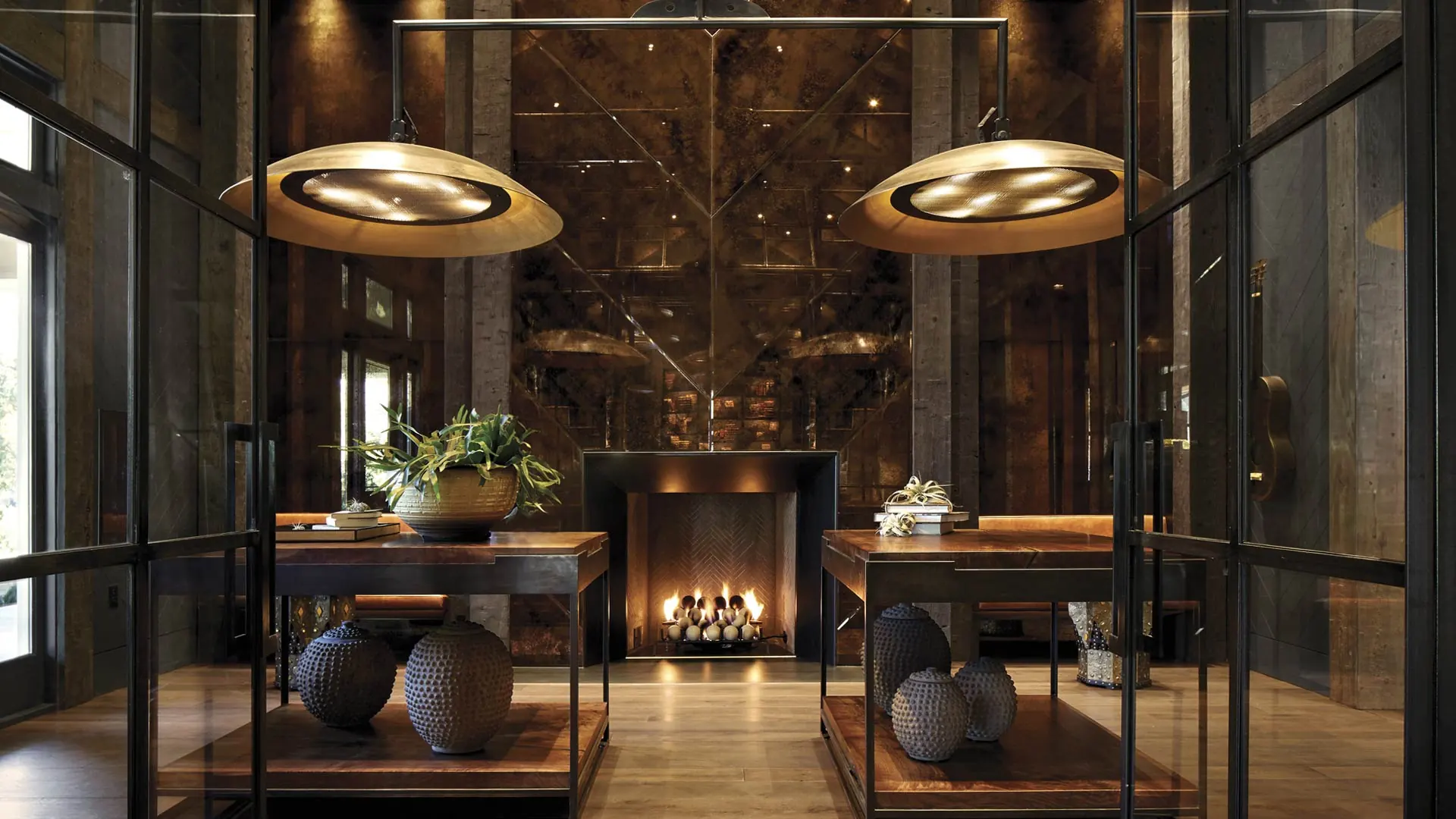 A hallway with a fireplace and glass doors.