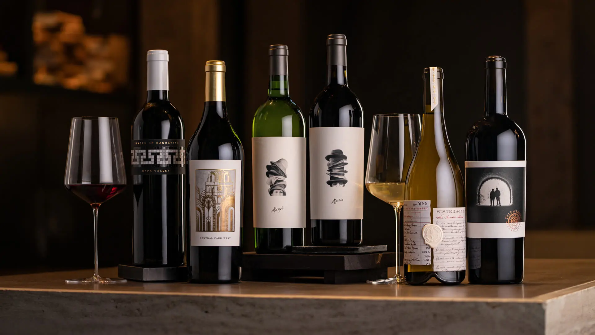 A group of wine bottles and glasses on a table.