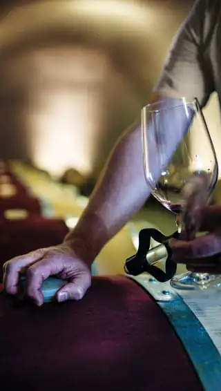 A man pouring wine into a wine glass.
