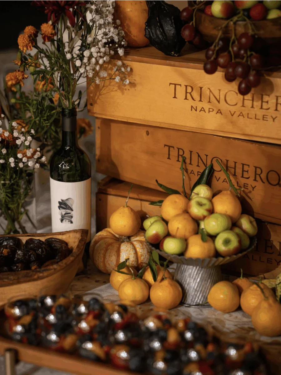A still life display featuring a wine bottle, wooden crates labeled 